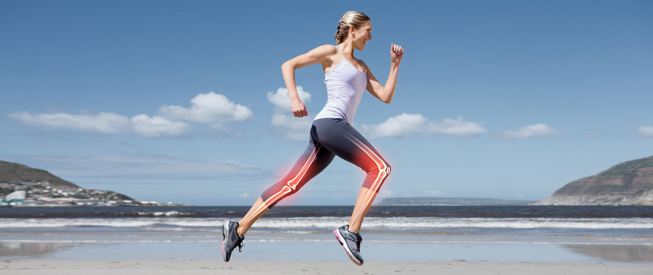 Eine Frau joggt am Strand. Die Knochen ihrer Beine sind zur Verdeutlichung grafisch eingefügt.