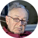 Johannes Klinger, 78 Jahre, ein älterer Herr mit Lesebrille, pflegebedürftig nach Schlaganfall