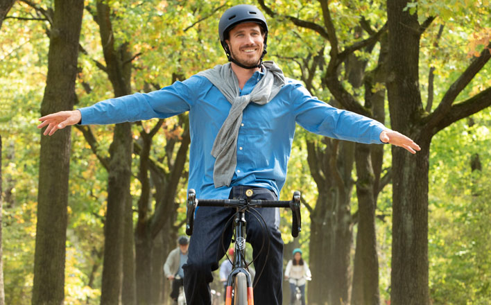 Ein Mann genießt die Fahrt zur Arbeit auf seinem Fahrrad.