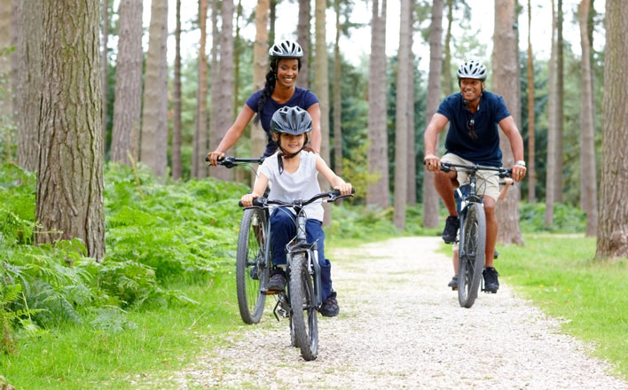 Eine Familie fährt Fahrrad im Wald.
