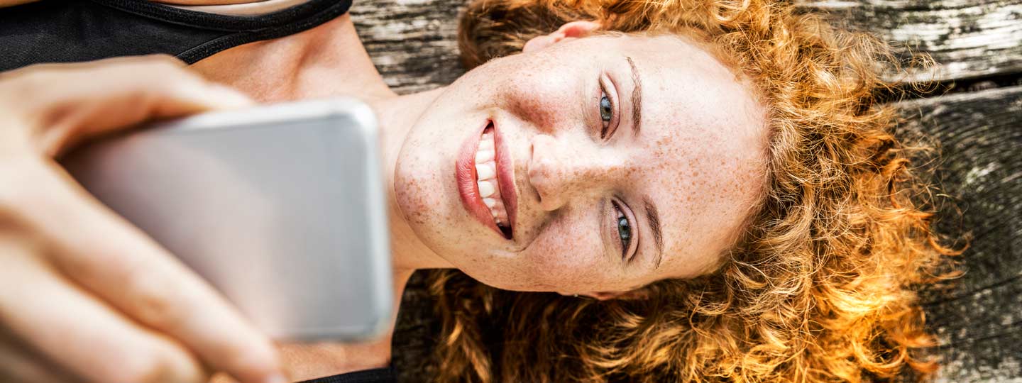 Elektronische Patientenakte. Eine Frau lächelt in die Kamera und liegt auf einer Bank.