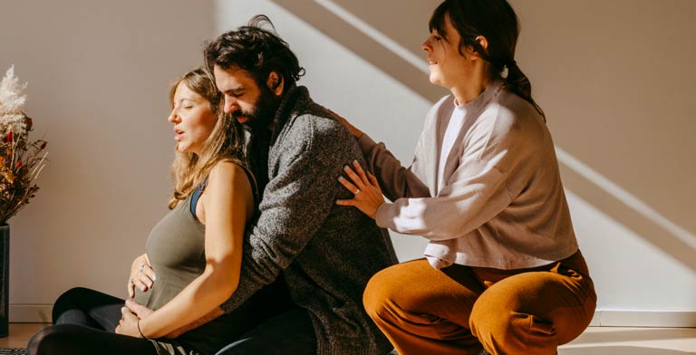 Mein Geburtsvorbereitungskurs von der Krankenkasse. Ein junges Paar nimmt am Geburtsvorbereitungskurs ihrer Krankenkasse teil und macht eine Atemübung.