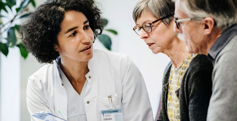 Individuelle Gesundheitsleistungen: IGeL. Ein Paar spricht mit einer Ärztin über die Kosten der individuellen Gesundheitsleistungen.
