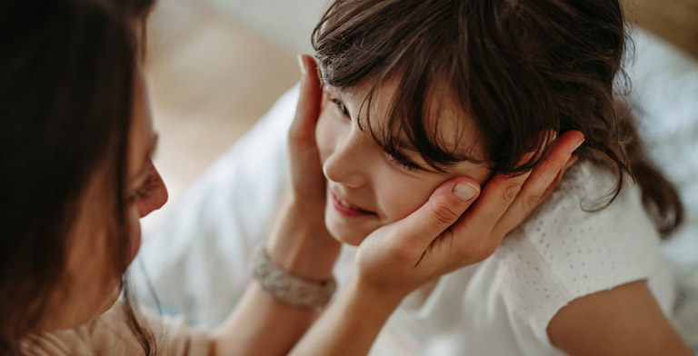 Unser Zusatzbeitrag steigt. Eine Mutter hält das Gesicht ihrer Tochter in beiden Händen.