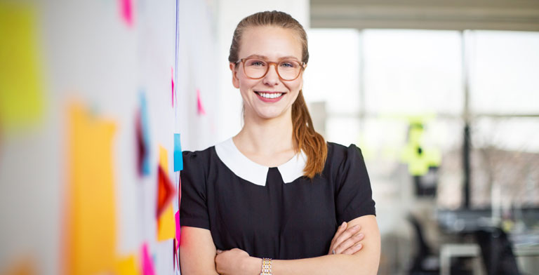 KNAPPSCHAFT - für meine Gesundheit! Ein Frau in einem Büro lächelt in die Kamera.