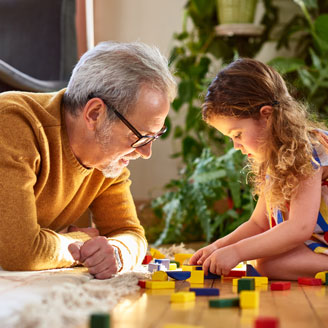 Ein Rentner spielt Bauklötze mit seiner Enkelin. Ein Rentner spielt Bauklötze mit seiner Enkelin.